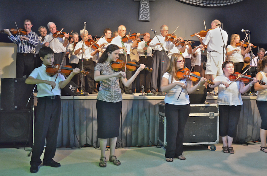 Cape Breton Fiddlers’ Association Third Group Number, directed by Eddie Rogers and accompanied by Lawrence Cameron on keyboards and James Boudreau on guitar