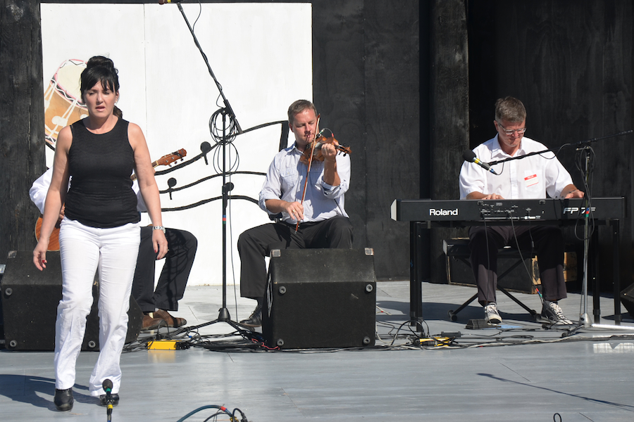 Maureen Fraser step‑dancing to the music of Rodney MacDonald on fiddle, Lawrence Cameron on keyboard, and Jesse Lewis (obscured) on guitar