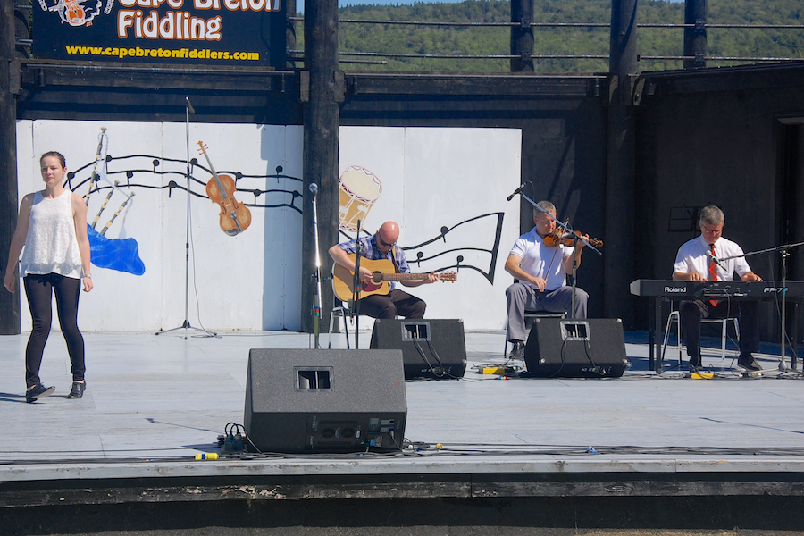 Stephanie MacDonald step‑dancing to the music of Rodney MacDonald on fiddle, Lawrence Cameron on keyboard, and Mike Barron on guitar