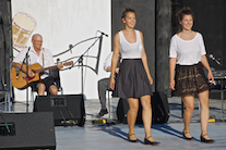 Lauren and Janelle Boudreau step-dancing to the music of Kyle Kennedy MacDonald (obscured) on fiddle and James Boudreau on guitar