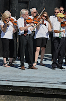 The Cape Breton Fiddlers’ Association plays its second group number in tribute