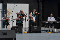 A contingent of the PEI Queens County Fiddlers accompanied by Kolten MacDonell on keyboard