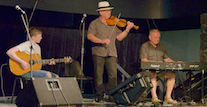Kyle MacNeil on fiddle, Sheumas MacNeil on keyboard, and Malcolm MacNeil on guitar