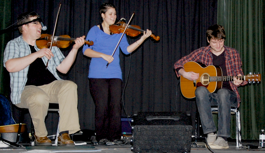 Photo of J. J. Chaisson and Zoë Darrow on fiddles accompanied by Koady Chaisson on guitar
